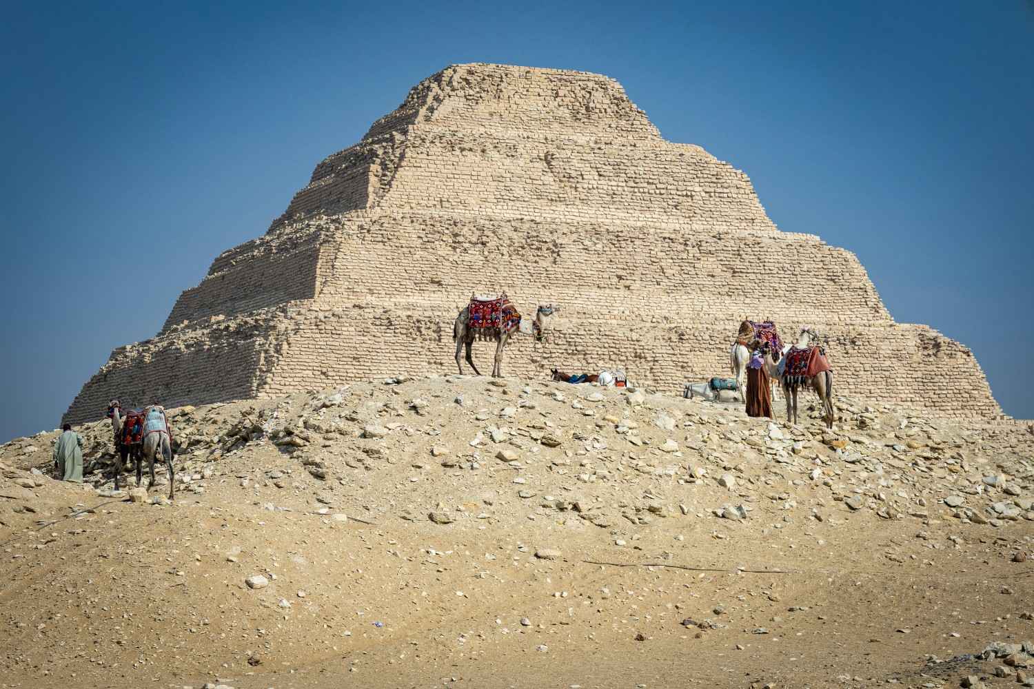 The smallest of the three main Giza pyramids showing granite lower courses and limestone upper sections with desert setting